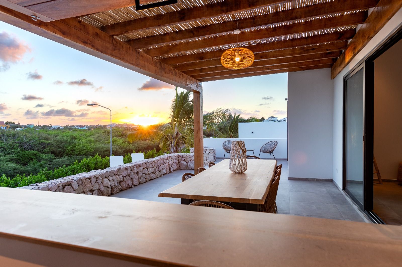 Overdekt terras met eettafel bij zonsondergang