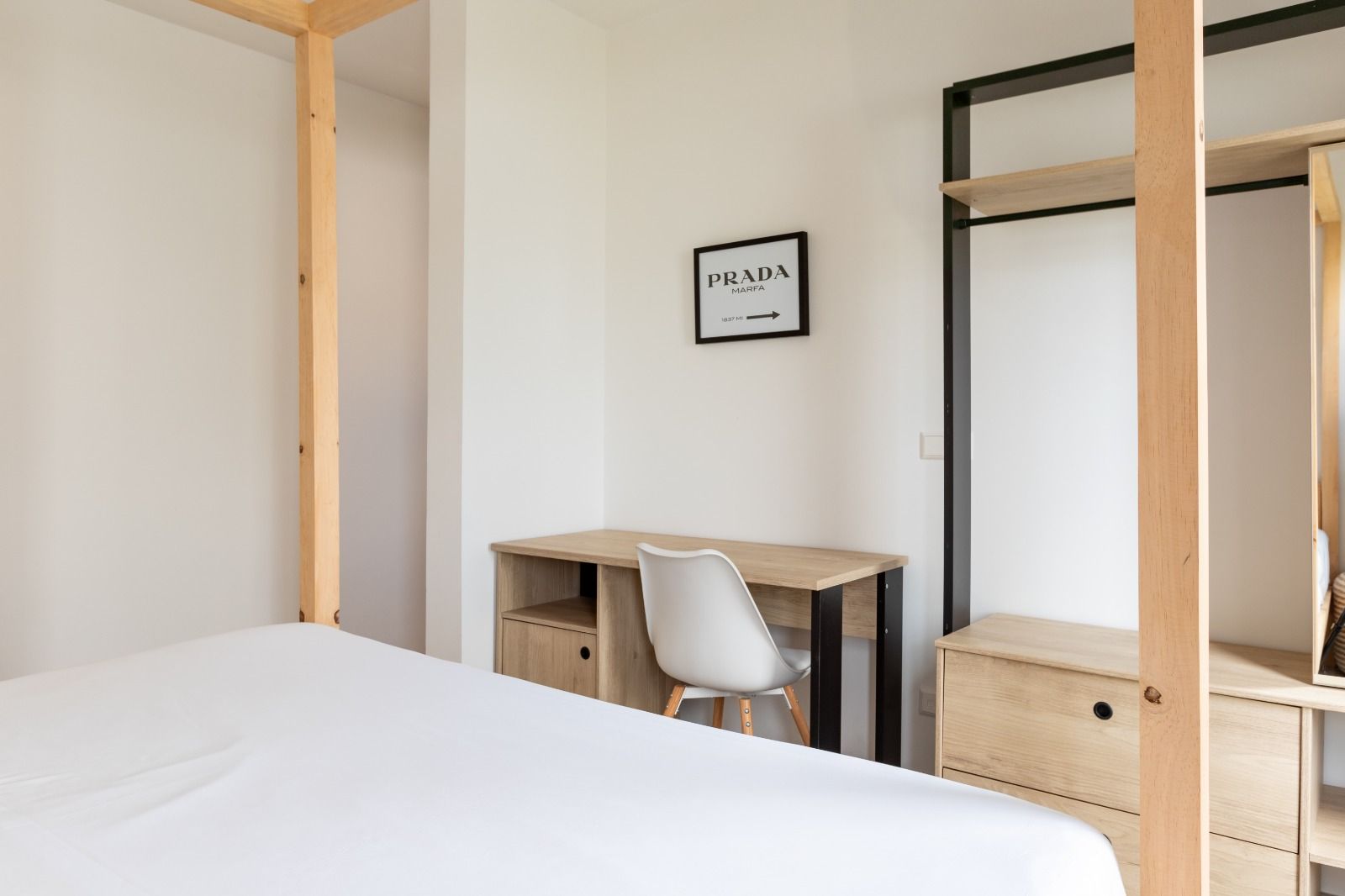 Slaapkamer met open kledingkast en werkplek