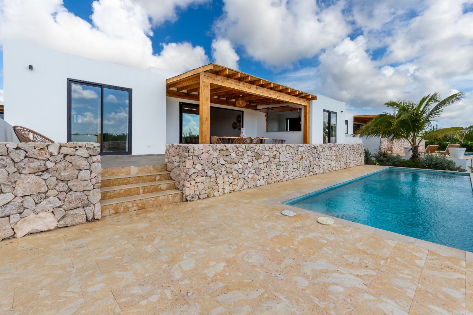 Zwembad met natuurstenen muur en pooldeck